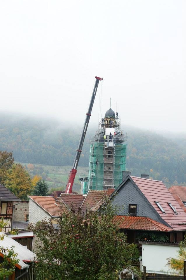 Der Kirchturm im Nebel mit dem Kran daneben, die Turmhaube sitzt oben